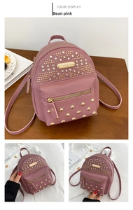 Detail of pink mini backpack featuring gold studs, rhinestones and headphone port