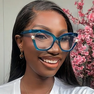 Detail of blue cat-eye glasses frame featuring decorative metallic sphere embellishments