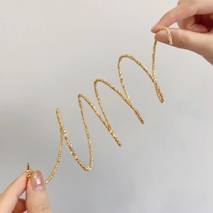 Vue détaillée du bracelet spirale perlé plaqué or flexible avec un éclat métallique