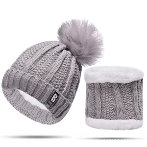 Detail of grey winter knit beanie and scarf set with thick white fleece lining and fur pom