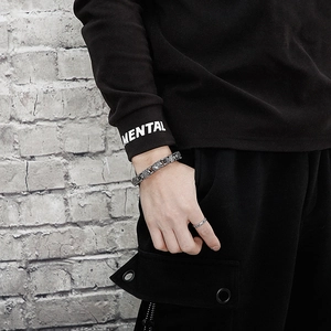 Men's hip-hop stainless steel cross link bracelet and ring on industrial gray wall