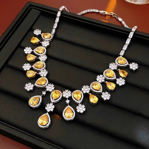 Close-up of luxury necklace with yellow pear-shaped zircons and floral silver tassels