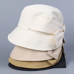 Detail of stacked elegant seersucker sun hats with bow and metal tag in multiple colors