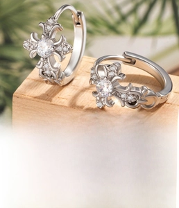 Detail view of silver lace cross hoop earrings featuring micro-pave cubic zirconia stones