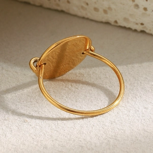 Minimalist 18K gold plated stainless steel ring with a polished oval disc on a neutral base