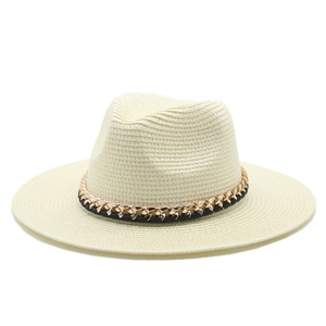 Detail of hand-woven straw Panama hat with a black band and decorative gold chain accent