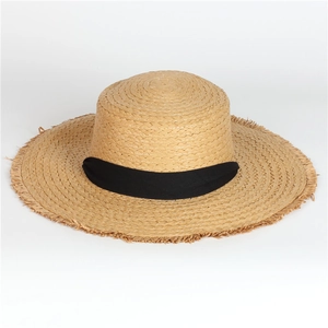 Detailed texture of woven straw boater hat with black ribbon and frayed edges