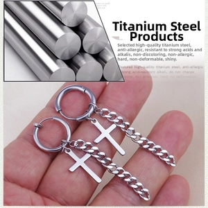 Detail of silver titanium steel cross earrings featuring polished dangles and fine chains