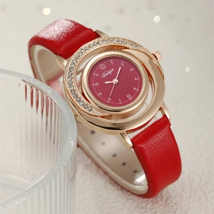 Close-up of red leather strap watch with sparkling rhinestone dial and gold case