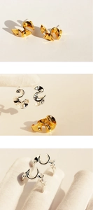 Close-up of polished silver and gold abstract wave pattern earrings and ring set