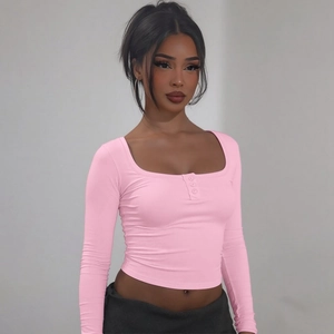 Détail du crop top rose à manches longues avec col carré et fermeture à trois boutons