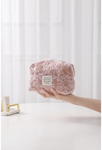 Close-up of pink corduroy makeup bag featuring 3D white lace floral embroidery details