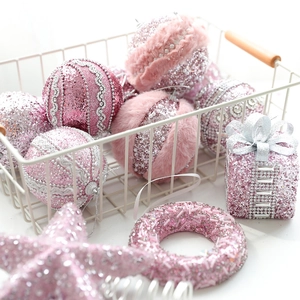 Pink Christmas ball ornaments and star topper in a white basket for holiday decor