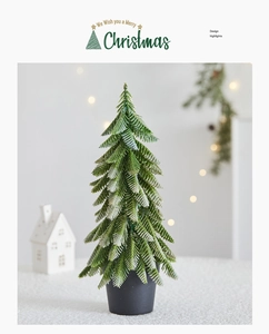 Mini artificial Christmas tree with realistic snow-dusted needles in a gray pot decoration