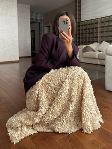 Detailed view of luxury 3D floral petals on a cream-colored maxi evening skirt