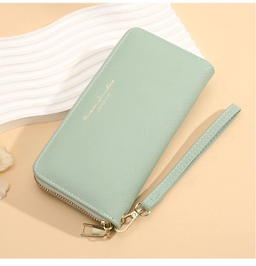 Detail of light green cross-grain long wallet with gold zipper and wristlet strap