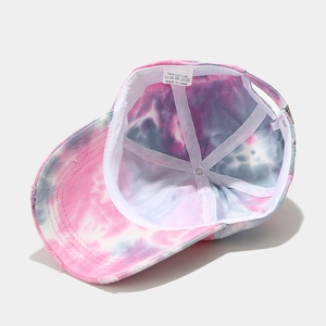 Detail view of tie-dye cotton baseball cap interior showing sweatband and 100% cotton label