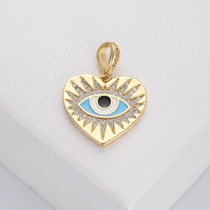 Macro shot of gold heart evil eye pendant with blue enamel and sparkling zircon accents