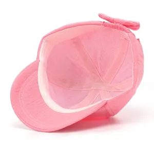 Pink cotton baby girl sun hat with bow detail and adjustable chin strap in outdoor setting