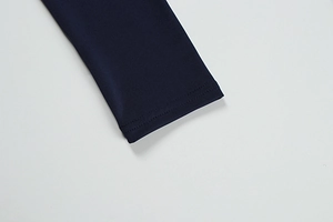 Detailed close-up of dark blue knit fabric sleeve with premium double-needle stitching