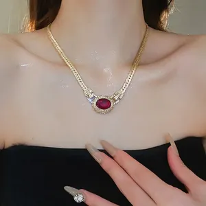 Vintage style gold chain necklace featuring an oval ruby pendant with zircon accents