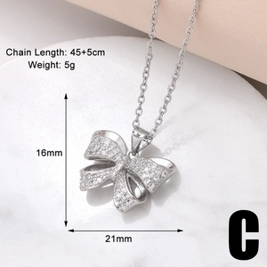 Macro detail of silver bow pendant with white zircon inlays and precise dimensions