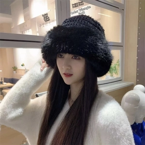 Detail of black faux fur hat with thick knit top on model for winter warmth