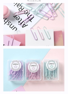 Vue détaillée de trois boîtes de trombones pastel en violet, rose et vert menthe