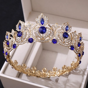 Detailed side view of golden bridal tiara with blue gemstones and rhinestones in gift box
