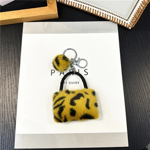 Nahaufnahme von Plüsch-Schlüsselanhänger mit Leopardenmuster, Mini-Tasche und Pelzbommel