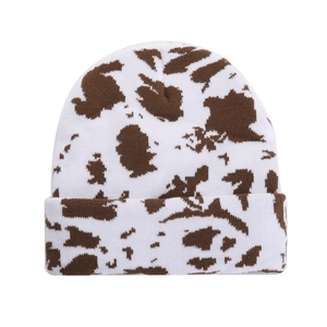 Winter knitted beanie with trendy cow print pattern in white and brown colors
