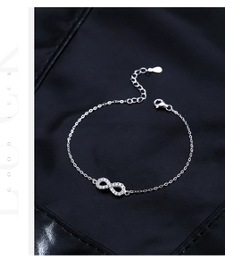 Macro shot of 925 silver infinity bracelet with pavé moissanite on black leather