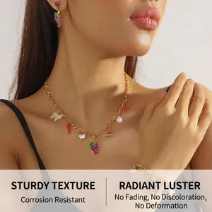 Detailansicht eines bunten Emaille-Fruchtschmucksets mit Weintrauben und Erdbeeren am Model