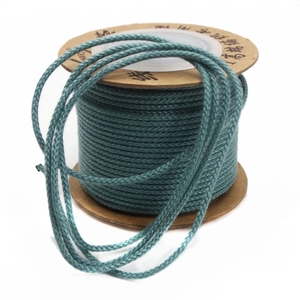 Close-up of high-strength dark green waxed cotton cord on a spool for DIY jewelry