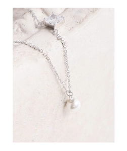 Close-up of S925 sterling silver necklace with square zircon and round pearl pendant