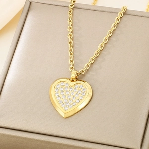 Golden heart pendant necklace with rhinestones on a champagne jewelry box main view