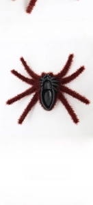 Macro detail of the realistic flocked spider prop with brown fur and plastic underside