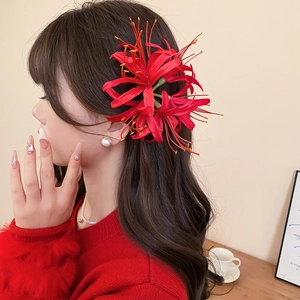 Detailed close-up of a red Lycoris flower hair clip with realistic fabric petals and stamens