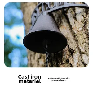 Macro detail of rustic cast iron welcome doorbell hanging on a tree trunk with pull rope