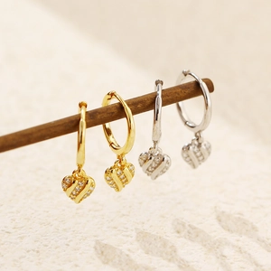 Close-up of gold and silver heart hoop earrings with shimmering cubic zirconia accents