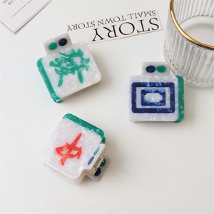 Macro detail of Mahjong-themed hair claw clips with marble texture acetate and metal spring