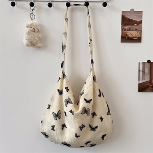 Close-up of lace butterfly pattern on canvas shoulder bag with natural fabric texture