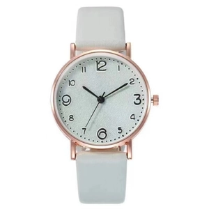 Détail d'une montre à quartz or rose avec cadran gris et bracelet en cuir