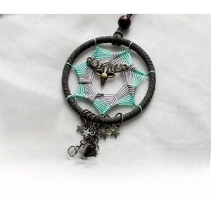 Macro shot of handmade bohemian dreamcatcher with mint green weaving and bronze deer head