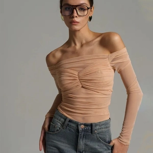 Detail of sheer mesh off-shoulder long sleeve top with textured pleats on model