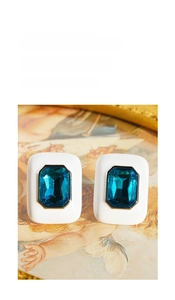 Close-up of vintage rectangle earrings with teal zircon and white enamel finish