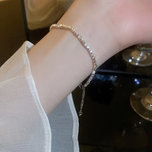 Close-up of adjustable silver bead bracelet with pearl detail on woman's wrist