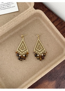 Detailed shot of ethnic hollow rhombus earrings with tiger eye beads and pearls