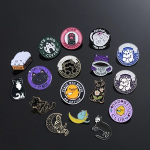 Collection of cartoon enamel cat pins and animal badges on a black reflective surface