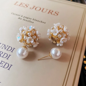 Detail of floral pearl earrings with golden cluster petals and large pendant drop